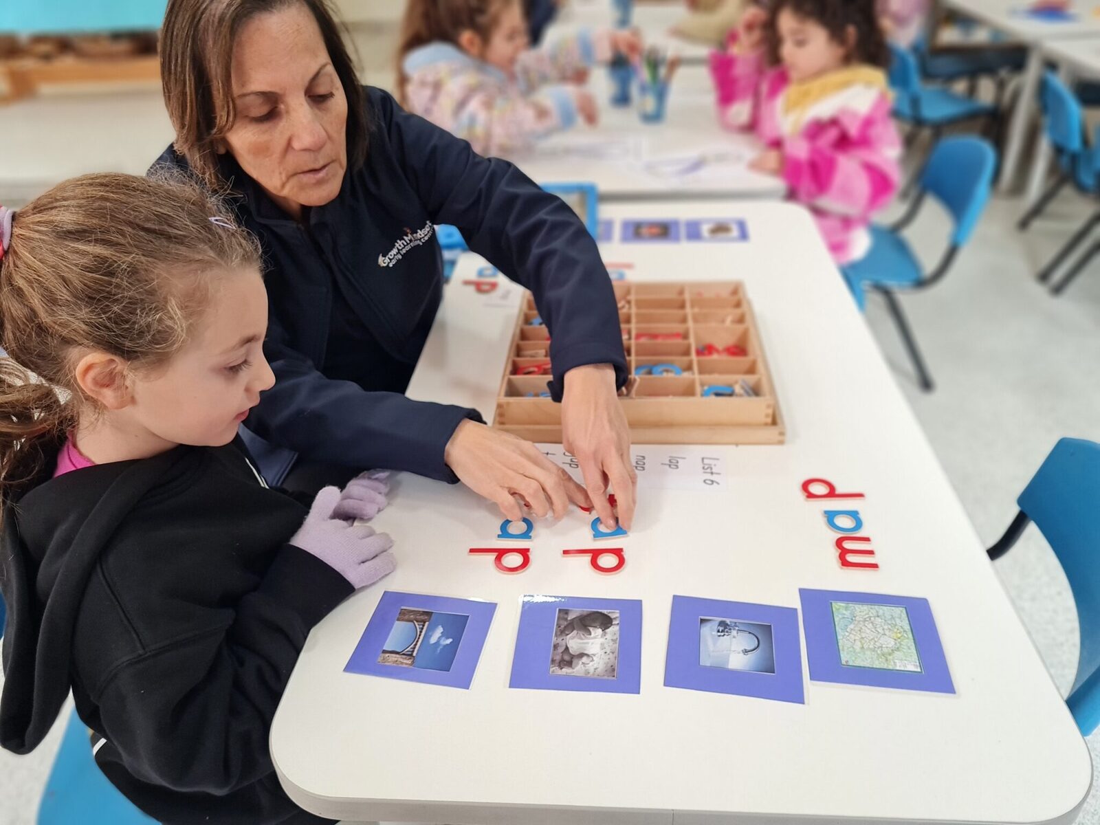 A Growth Mindset educator guiding a child through letter sounds